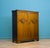 Compact 1930s oak gentleman’s wardrobe with carved roundel decoration, panelled doors and fitted interior. The layout...