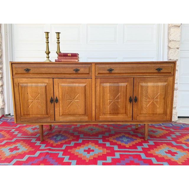 A fantastic vintage Danish oak sideboard attributed to Henning Kjærnulf, blending Scandinavian functionality with the...