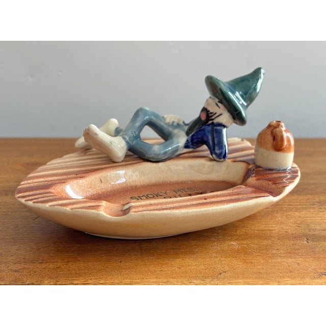 Midcentury Smoky Mountains souvenir ceramic ashtray with a reclining hillbilly relaxing with his whiskey. Perfect addition...