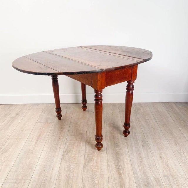 A pine dropleaf table, U.S.A., 19th century. Width measures 50.5" when open, 18.5" when closed.