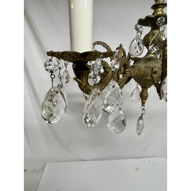 Brass and Crystal French Style Chandelier featuring two sizes of shimmering crystals mounted on a detailed brass frame....