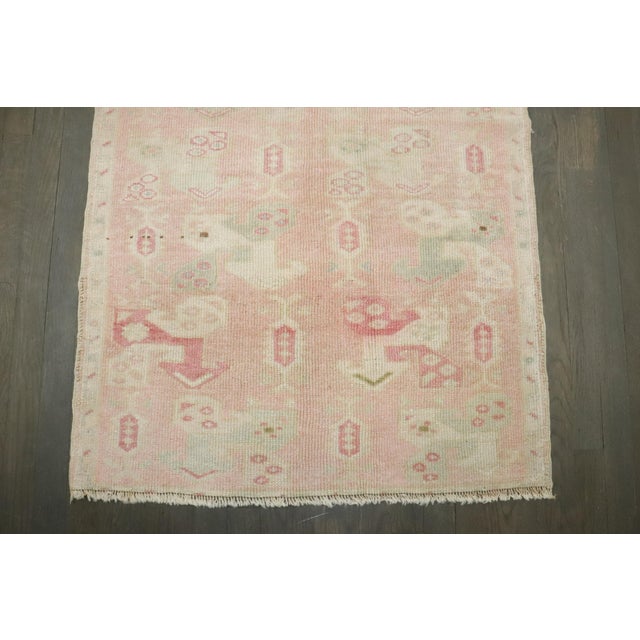 a mid 20th century floral turkish anatolian rug in pinks, creams soft greens