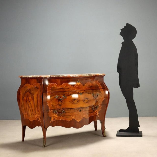 Lombard Barocchetto style chest of drawers, dating back to the early 1900s, featuring an elegant walnut and mahogany burl...