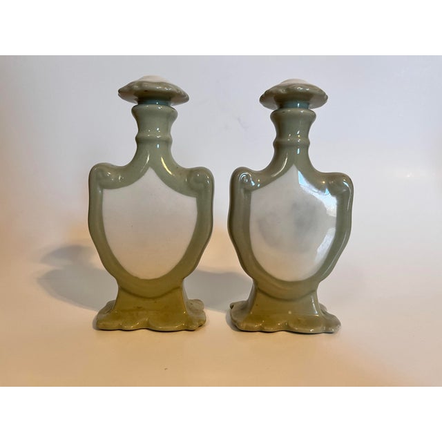 Vintage ceramic pair of perfume bottles with decanters. Pastel green and white. The bottom of the bottles have no markings.