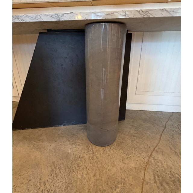 Striking console table with a dramatic solid marble cantilevered top. It has a combined cylindrical marble and geometric...