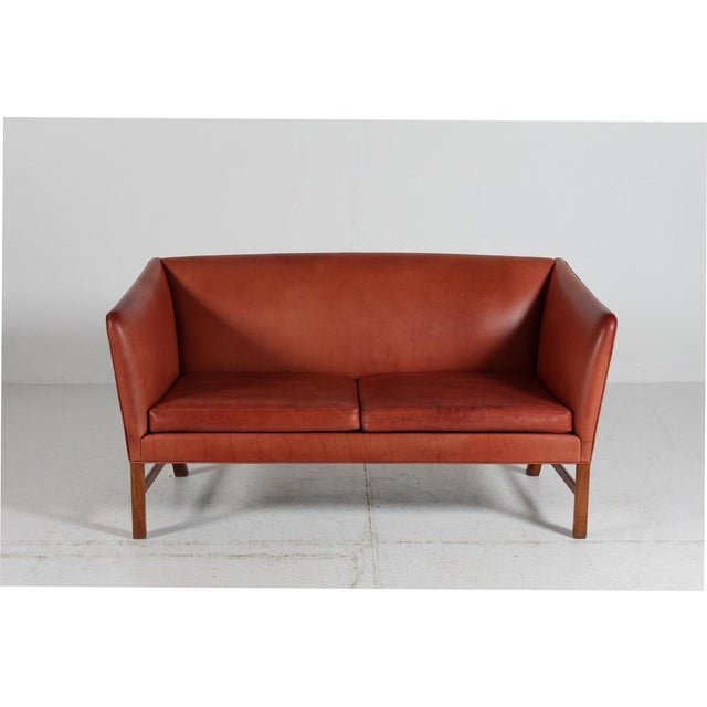 2-seater sofa with frame of walnut upholstered with cognac colored aniline leather. Model OW602 designed by Ole Wanscher...