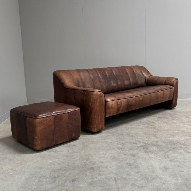 Vintage De Sede 3 seater sofa with hocker, model DS 44. Switserland 1970s. Brown, thick neck leather upholstery. Sofa and...