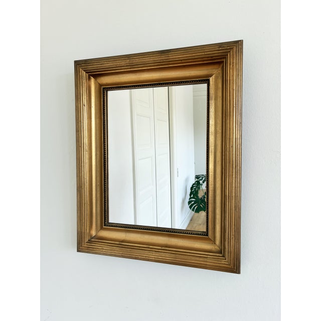 A pair of antique Danish giltwood wall mirrors, dating to the late 19th to early 20th century. The rectangular wooden...