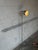This sleek metal floor lamp features a slender stem and a flexible gooseneck arm supporting a directional shade. It...