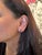 These beautiful stud earrings feature a pair of 2.86 carat weight pear cut ruby gemstones with a halo of natural earth...