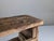 A rustic wooden bench or stool, crafted using traditional methods, whose aesthetic pays tribute to simplicity and the...