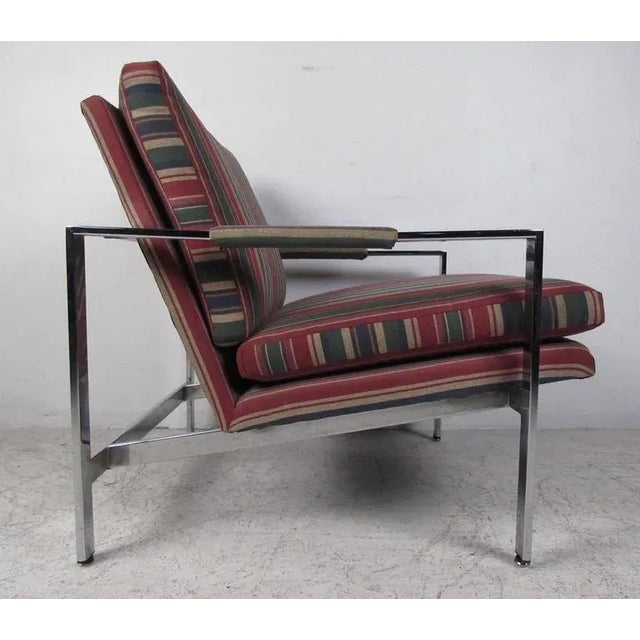 Flat stock chrome frame with upholstered cushions and arm pads create a comfortable and classic lounge chair suitable for...