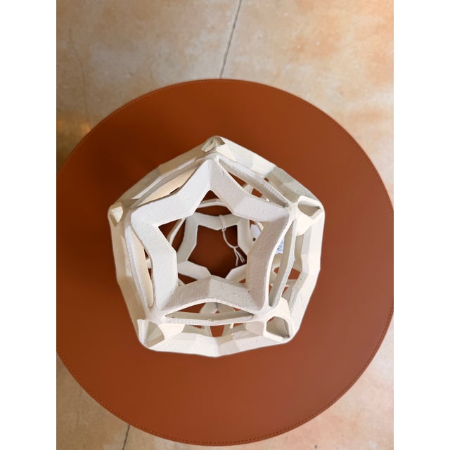 Contemporary aluminum decorative piece featuring a striking star-inspired design with intersecting geometric points that...