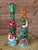 Playful pair of hand-painted ceramic mermaid candlestick holders featuring bold colors, sculptural detailing, and lots of...