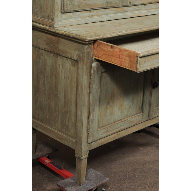 A tall Italian painted wood bookcase cabinet, with wire front doors, from the mid 19th century. This antique cabinet from...