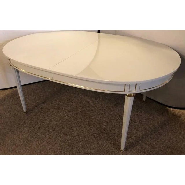 A Hollywood Regency dining table in gray lacquered bronze mounted finish in the manner of Maison Jansen. The Louis XVI...