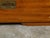 An English camphor wood Campaign low chest from the 19th century, with three drawers and inset brass hardware. Created in...