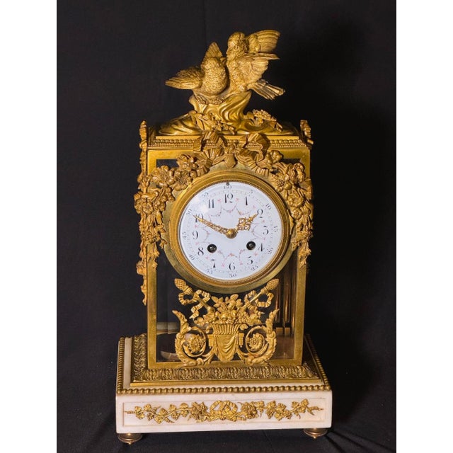 An exceptional 19th-century French Louis XVI-style clock set, composed of a central mantel clock and a matching pair of...