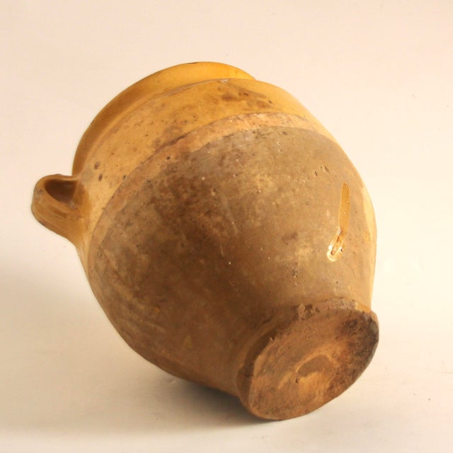 This antique Anduze ceramic pot is partially glazed in yellow, with charming weathering in various places. The pot has a...