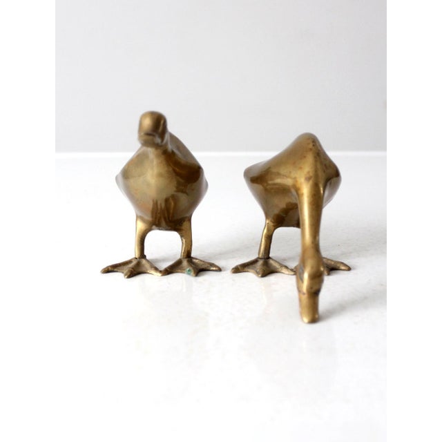 This is a pair of mid 20th century vintage brass geese figures. The brass birds have sleek modern lines with a lovely...