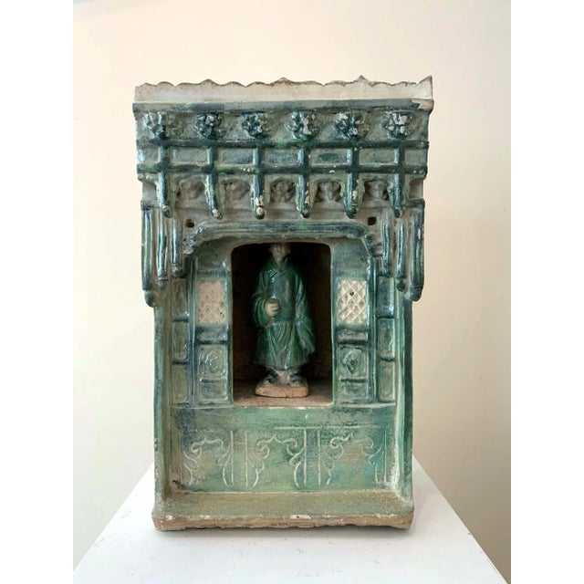 A stoneware shrine model with a figurine made in Ming dynasty (15th-17th century) in China and used as funeral burial...