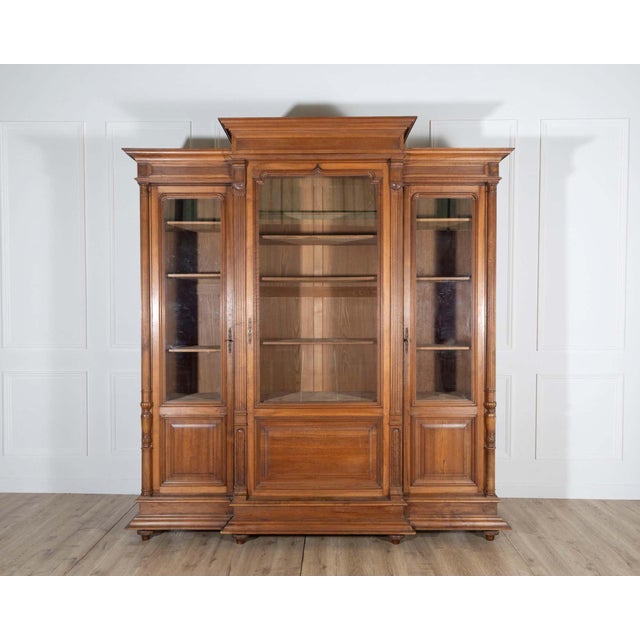 A grand French bookcase in solid walnut, dating to the late 19th century, showcasing both elegance and durability. The...