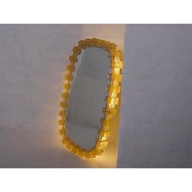 Illuminated amber acrylic mirror, supported by a white metal frame equipped with six lights, from the 1970s. cord-operated...