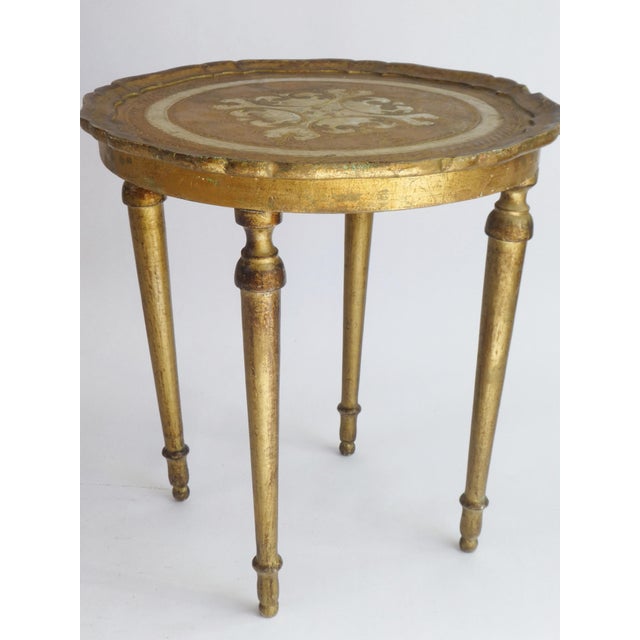 A round mid century Florentine style golden with white side table. The Florentine table is made out of wood and has a nice...