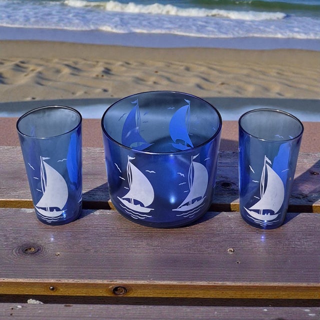 The Vintage Hazel Atlas Sportsman Cobalt Blue Nautical Sail Boat Ice Bucket with two Glasses is a charming set of mid-...