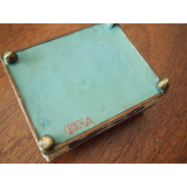 Beautiful Chinese blue and white cloisonne box raised on small brass feet. White ground with blue floral design. Signed...