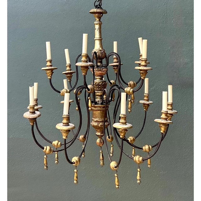 Exuding European elegance, this vintage twelve-light chandelier pairs hand-carved gilded woodwork with slender, sweeping...