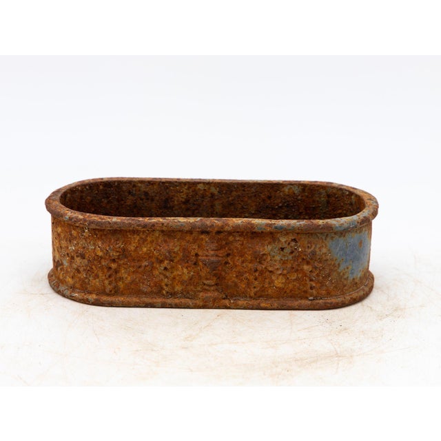 This French late 19th-century small cast iron planter embodies Neoclassical elegance in a compact, oval shape. The planter...