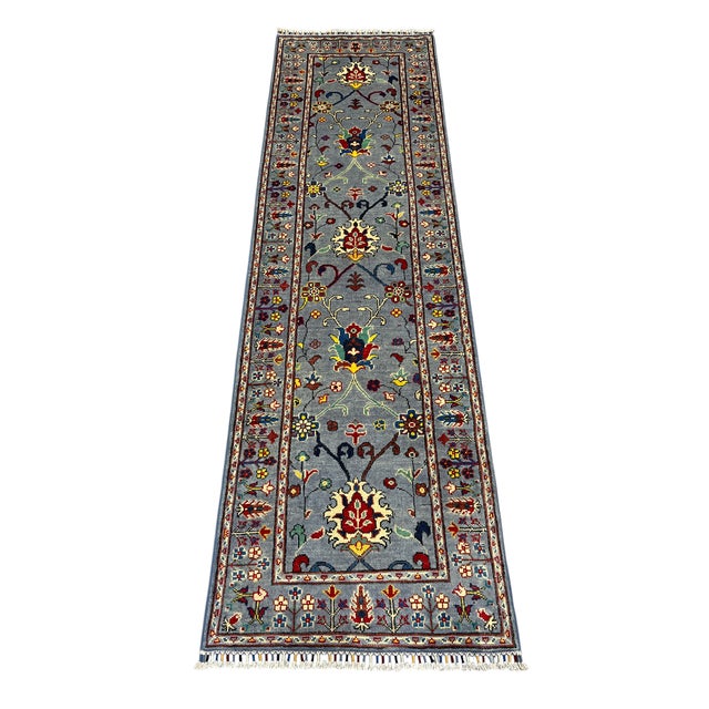 This Persian-style wool runner has a blue gray field filled with scrolling vines and stylized floral motifs. Red, cream,...