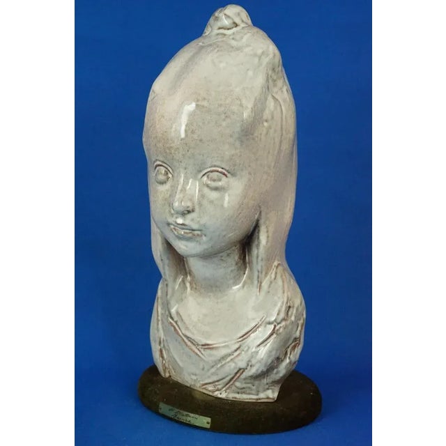 Item Description: A stunning sculpture depicting the bust of a little girl, made of glazed terracotta with a lustrous...