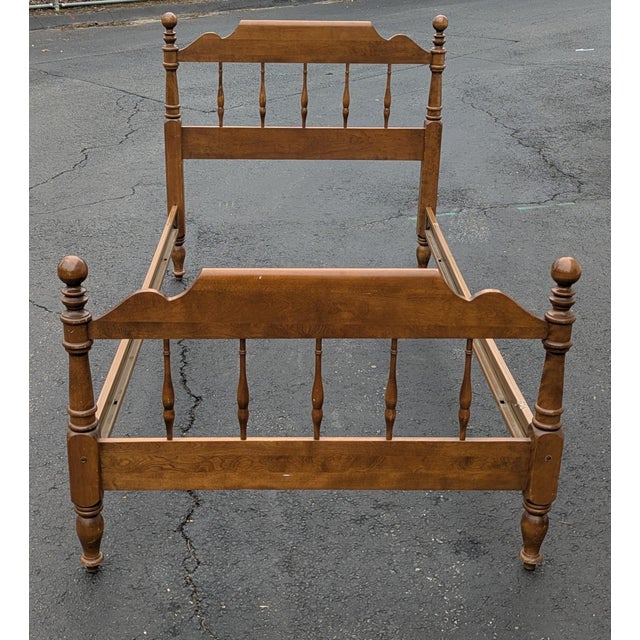 A late 20th century Ethan Allen Heirloom collection Rustic Traditional solid maple twin spindle bed. Includes headboard,...