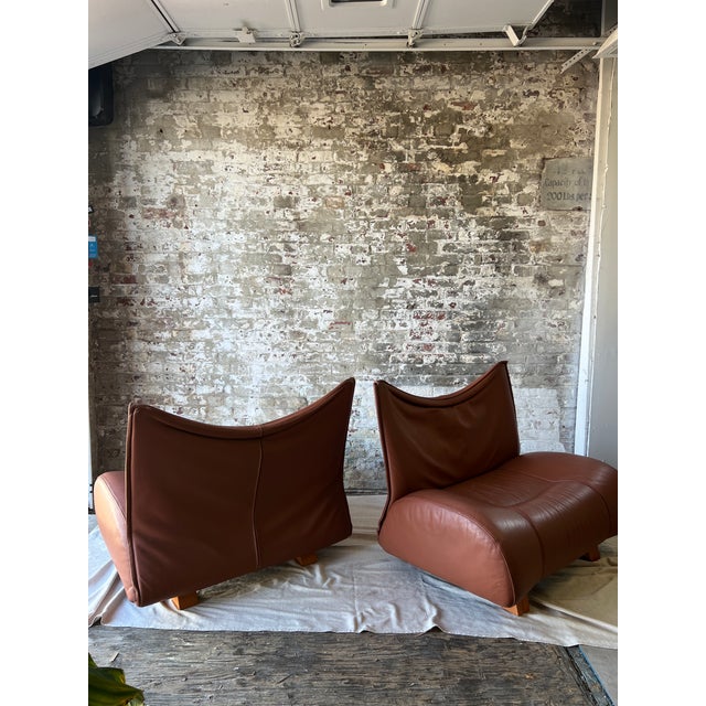 A sculptural and incredibly comfortable pair of vintage leather sling lounge chairs in a rich cognac saddle-tone leather....