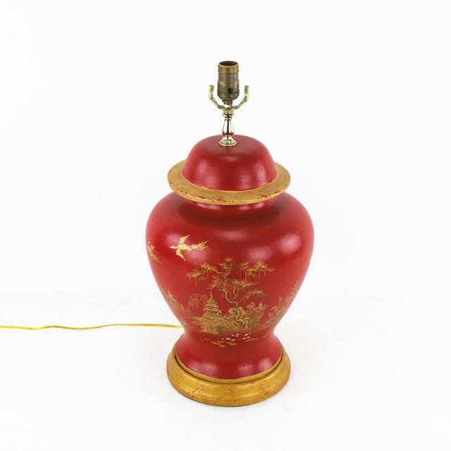 This vintage table lamp showcases an elegant temple jar silhouette, hand-painted in vivid red with intricate gold...