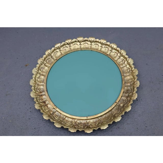 A beautiful mirror in a decorative frame made in the 1950s. A brass mirror frame. The surface of the mirror without...
