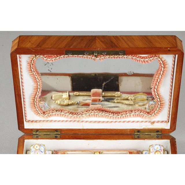 Precious rectangular sewing box in rosewood veneer called. Uncovered, it presents a mirror with braids on the back of the...