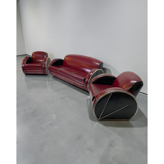 Attributed to Donald Deskey, this 1980s Streamline Moderne seating suite comprises one sofa and two armchairs, upholstered...