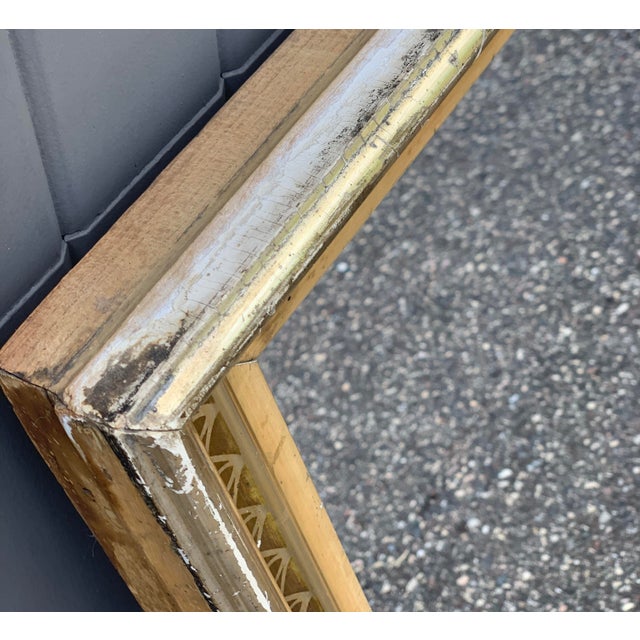 Vintage mid-century Hollywood Regency wall mirror featuring a wide gilt wood frame with an inset border of decorative...