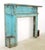 Georgian style fireplace mantel made of blue painted wood. It features a fluted frieze and jambs with bullseye block ends....