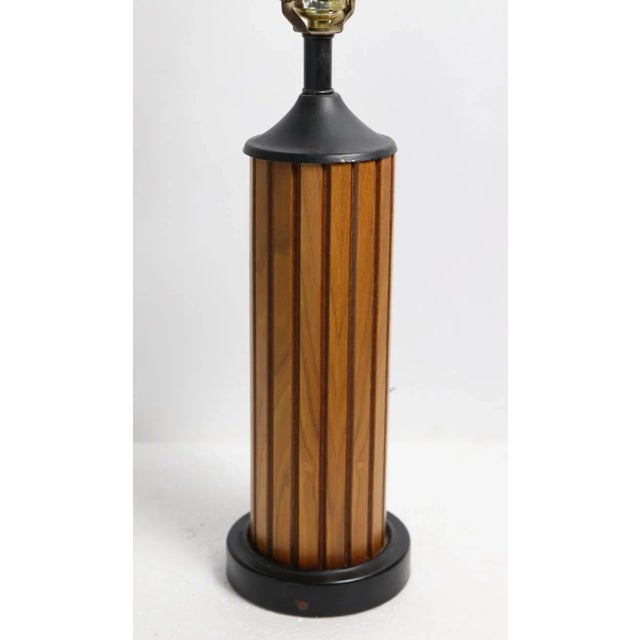 Cool Mid Century Gruvwood table lamp, having a fluted wood column, mounted on black metal base. This example is in very...