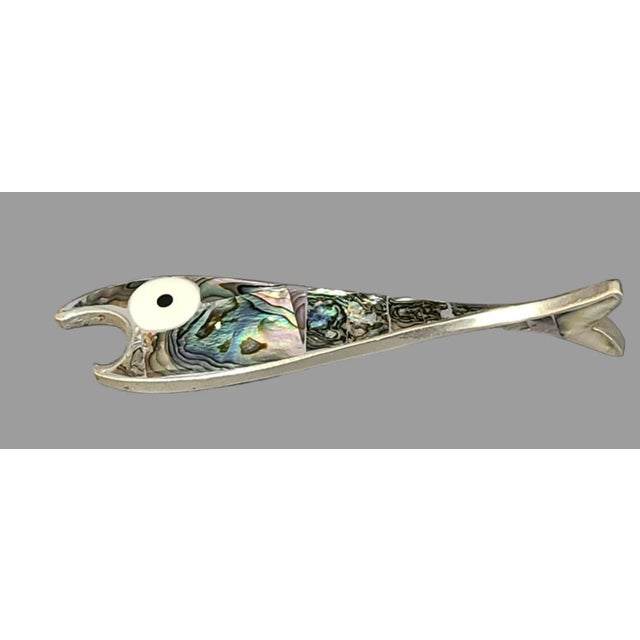 This vintage bottle opener featuring an abalone fish design is a unique collector's item. Made of Mexican alpaca silver,...