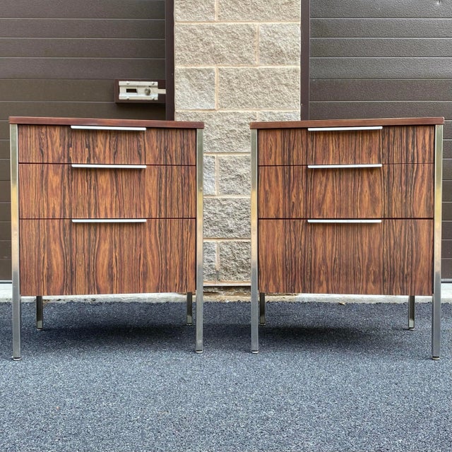 Pair of vintage rosewood laminate three drawer nightstands featuring stainless steel legs and drawer pulls and solid wood...