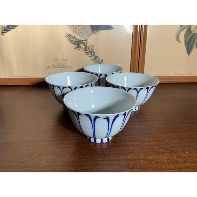 A stunning set of four vintage Japanese Arita-style porcelain footed rice bowls featuring an elegant hand-painted cobalt...