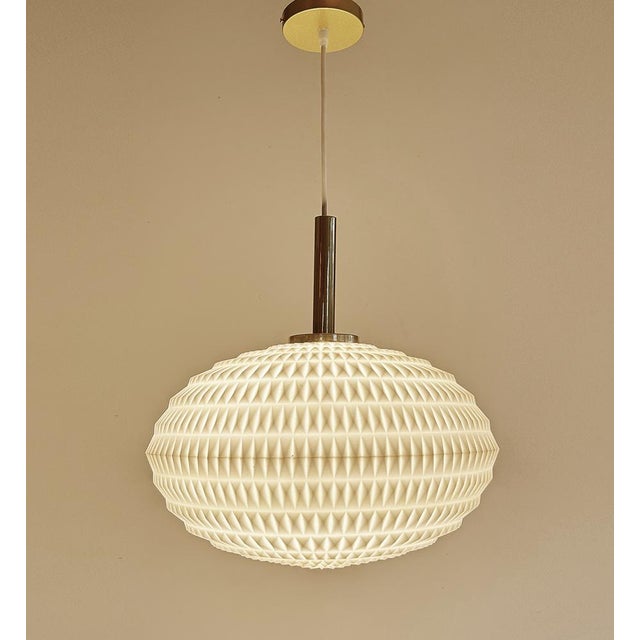 Mid century vintage cocoon pendant light with a flattened composite acrylic globe shade with diamond relief patterns and...