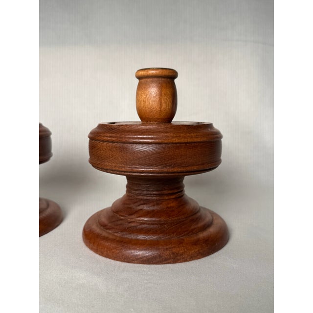 A pair of Mid Century Modern solid wood turned candle holders are in a warm light chestnut stain, carved throughout with a...