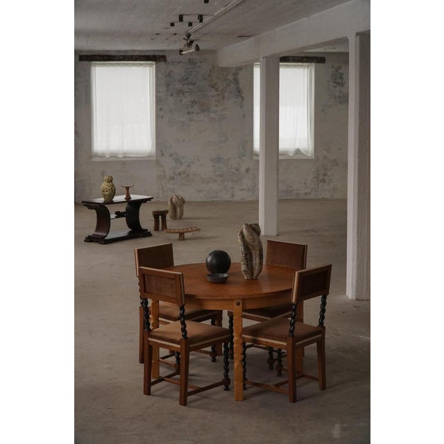 A classic round dining table crafted in solid oak, produced in the 1960s by a Danish Cabinetmaker. The table features a...