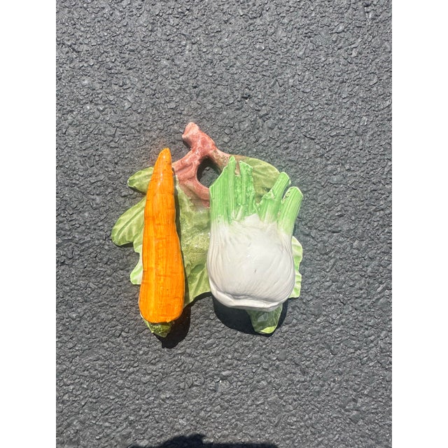 Trompe L'oeil porcelain wall plaque featuring an onion and a carrot atop a leaf. Can be hung on a wall or set on a table...